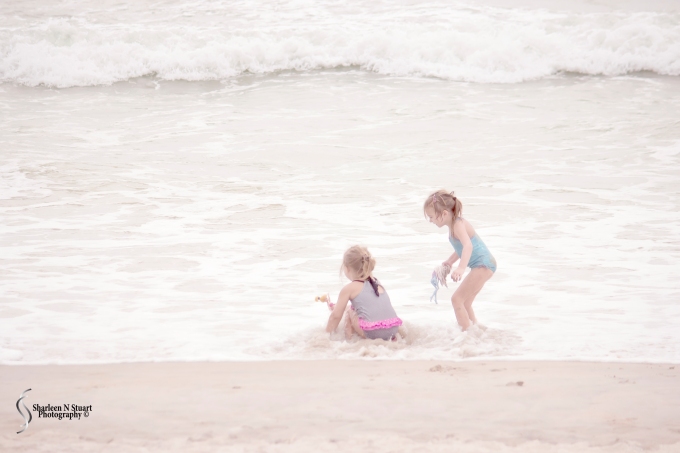 Two little girls playing on the beach